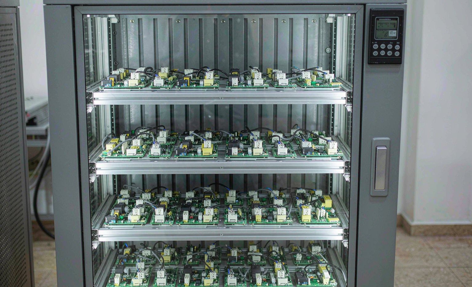 Automotive electronic control units and sensors stored on shelves inside a moisture-proof dry cabinet